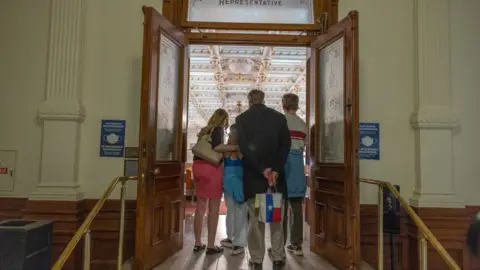 A trans youth and her family attends a rally in support of trans rights at the Texas State Capitol