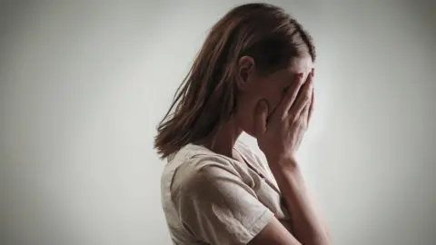 Getty Images Woman with head in hands