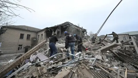 Reuters Rescuers work at the site of a maternity ward of a hospital destroyed by a Russian missile attack, as their attack on Ukraine continues, in Vilniansk, Zaporizhzhia region, Ukraine 23 November 2022.