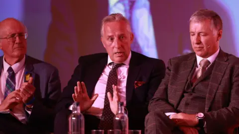 PA Media Jim Shannon MP, Ian Paisley Jnr MP and Paul Girvan MP during the DUP's annual conference at the Crowne Plaza Hotel in Belfast.