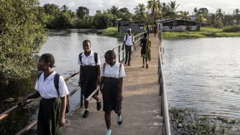 Getty Images Girls coming home from school in Liberia