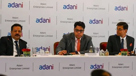 Getty Images Adani Enterprises group board members (L-R) executive vice president Raghwendra Pande, corporate finance head Anupam Misra (C) and head of finance of Adani airport Rakesh Tiwari attend a news conference on the FPO