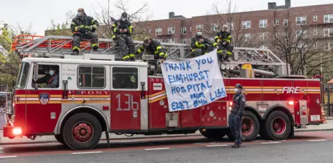 Getty Images Firefighters in Queens applaud medical staff