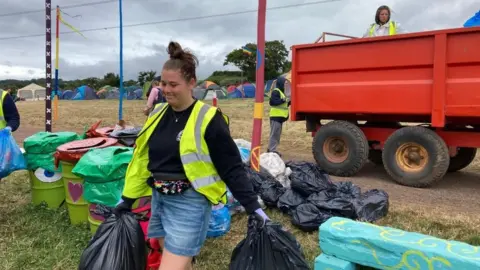 A woman carrying bags of rubbish