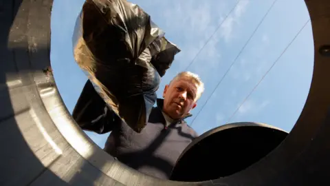 Getty Images man putting rubbish in bin