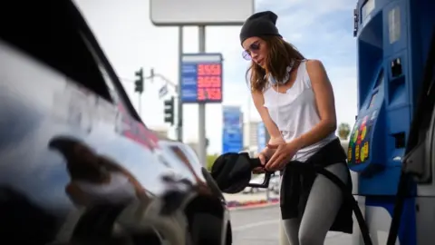 Getty Images a woman pumping gas