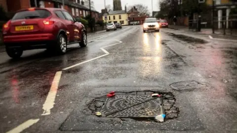 David Shenton The manhole cover repaired with rubber gloves