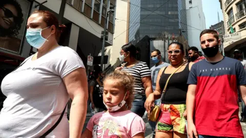 EPA People shopping in São Paulo, walking next to each other without social distancing