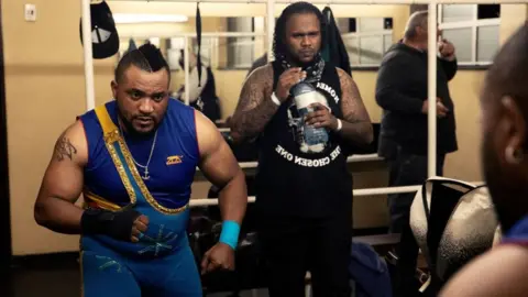 Gianluigi Guercia/AFP Wrestler Zephy from the Democratic Republic of Congo gets ready ahead of the Four Men Tag Match during the Africa Wrestling Association Nights of Champions in Cape Town on October 3, 2023.