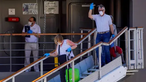 Getty Images Passengers leaving the Le Boreal cruise ship in Rio de Janeiro on 26 March