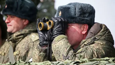 Getty Images Russian solider looks through a pair of binoculars