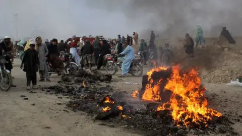 Getty Images Residents gather after Taliban forces fired mortars at Pakistan's border town of Chaman on December 11, 2022