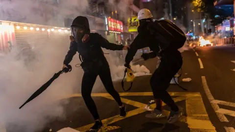 Getty Images Pro-democracy protesters react as police fire teargas during a demonstration in Wan Chai district on November 2, 2019 in Hong Kong, China.