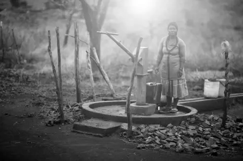 Mario Macilau Angeline Macamo next to a water pump