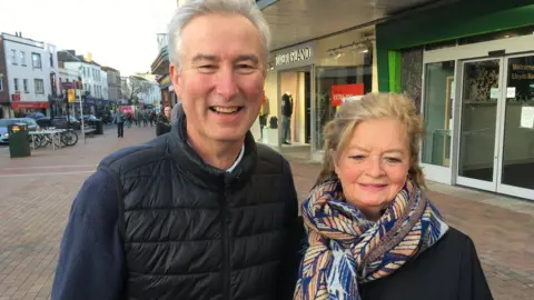 a man and woman outside some shops