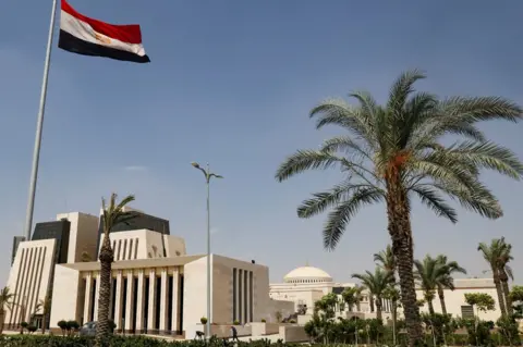 Reuters Egyptian workers are seen in front of the new headquarters of Egypt's parliament in the New Administrative Capital (NAC), east of Cairo, Egypt (21 June 2023)