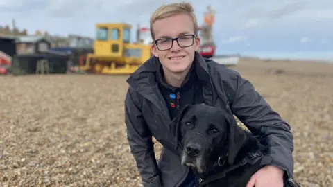 Ann Jillings Daniel on a beach with his dog