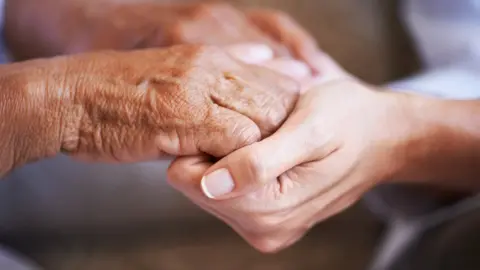 Getty Images Young and older women holding hands