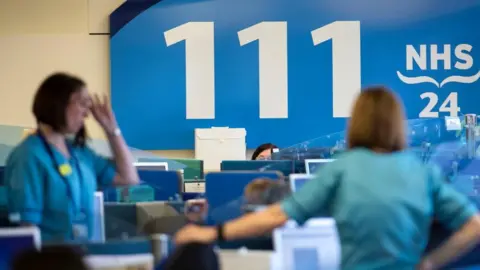 PA Media Staff at an NHS 111 centre in Glasgow