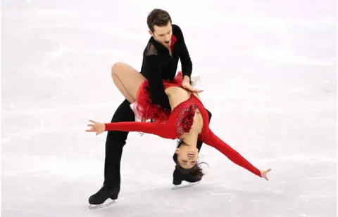 Getty Images Yura Min and Alexander Gamelin perform their routine with Yura's arms outstretched