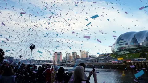 BBC Tickertape falls from the sky on Newcastle Quayside as crowds line the bank