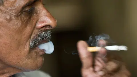 Getty Images An Indian man smokes a cigarette in New Delhi.