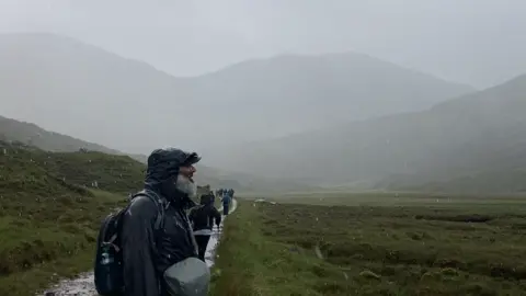 A Muslim pilgrim standing in the rain