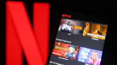 Getty Images Netflix logo with Netflix on phone