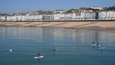 Reuters Paddle boarders in the sea at Hastings