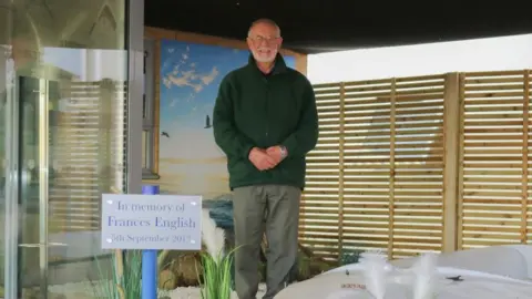 Queen Elizabeth Hospital Gavin English standing in the refurbished Peace and Hope Garden