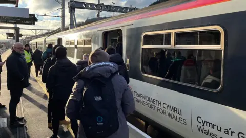 BBC Commuters get on the Treherbert to Cardiff train on Monday