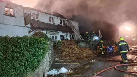 Buckfastleigh Fire Station The Jolly Sailor Pub with burnt roof and fire fighters