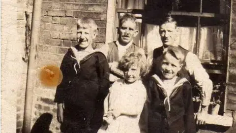 Family photo Five-year-old May Mitchell, as she was called then, with her father, Edward, Uncle Sid, who was to adopt her two years later, and two of her cousins