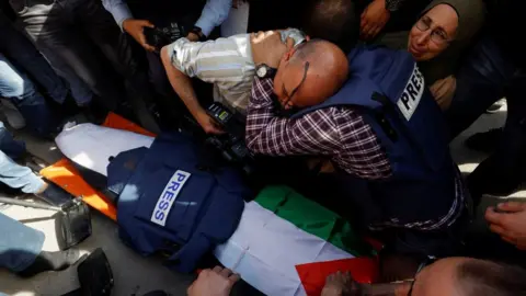 Reuters Journalists mourn next to the coffin of Al Jazeera correspondent Shireen Abu Aqla (11 May 2022)