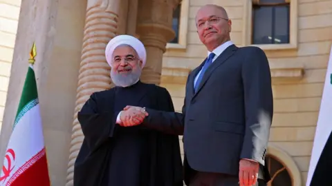 AFP Iranian President Hassan Rouhani (L) shakes hands with Iraqi President Barham Saleh in Baghdad (11 March 2019)