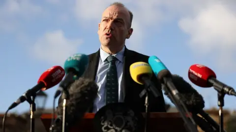 PA Media Chris Heaton-Harris stands behind a range of microphones at a press conference