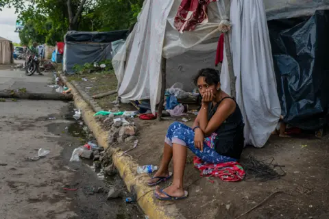 Encarni Pindado Susan Jesenia Aguilar sits in front of the makeshift tent where she has been living since her home flooded.