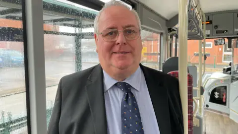 Shaun Whitmore Bus owner Charles Sanders on one of his buses