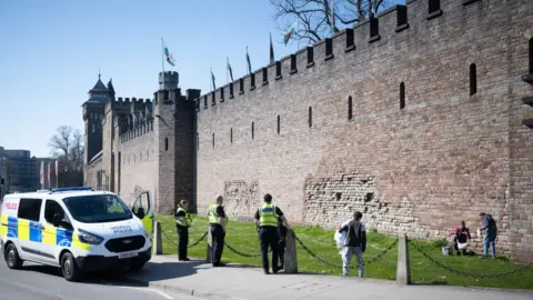 Getty Images Police move on a group of three people from Cardiff Castle