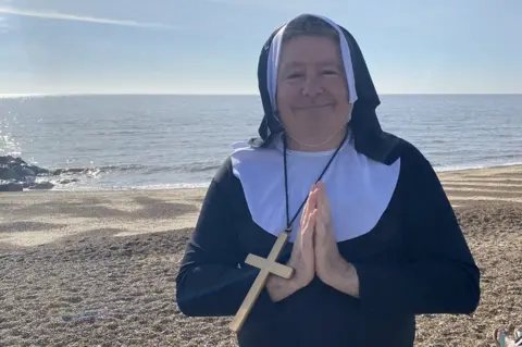 St Elizabeth Hospice Tim Kenny dressed as a nun at Felixstowe beach