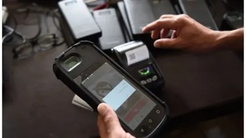 Getty Images An Independent Election Commission worker tests a biometric device at a warehouse in Kabul.