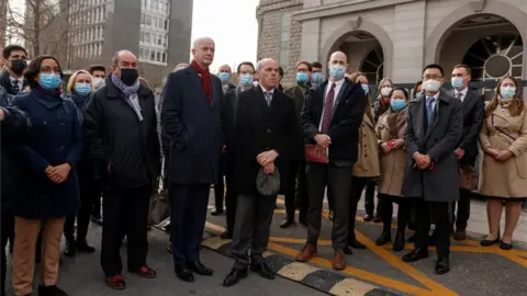 Reuters Group of men wearing facemasks