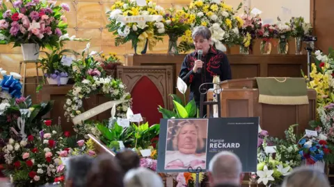 AFP A woman speaks during the funeral of Margie Reckard