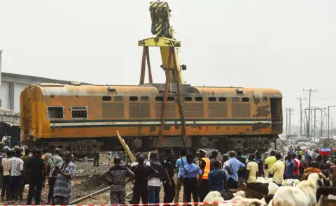 AFP Crane lifts a railway carriage back onto tracks in Lagos, Nigeria - Thursday 10 January 2019