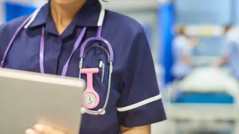 Getty Images A nurse works on a hospital ward - stock image