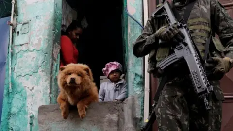 Reuters Armed Forces members patrol, as residents watch, during an operation against organized crime in Manguinhos slum complex in Rio de Janeiro, Brazil, August 21, 2017.