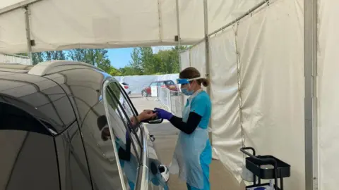 BBC Person having finger prick test through car window