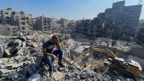 Reuters A man reacts as Palestinians search for casualties a day after Israeli strikes on Jabalia refugee camp, in the northern Gaza Strip (1 November 2023)