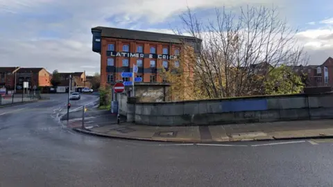 Google Road sweeps by old toilet building and old factory.