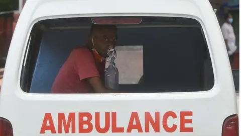 Getty Images Health Workers carry COVID 19 patient in ambulance in New Delhi